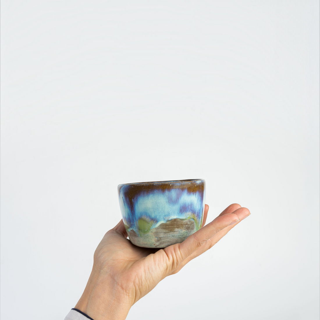 Handgefertigter havaneser.shop Galaxy Glaze Becher mit einzigartiger blau-grüner Keramikglasur auf weißem Grund