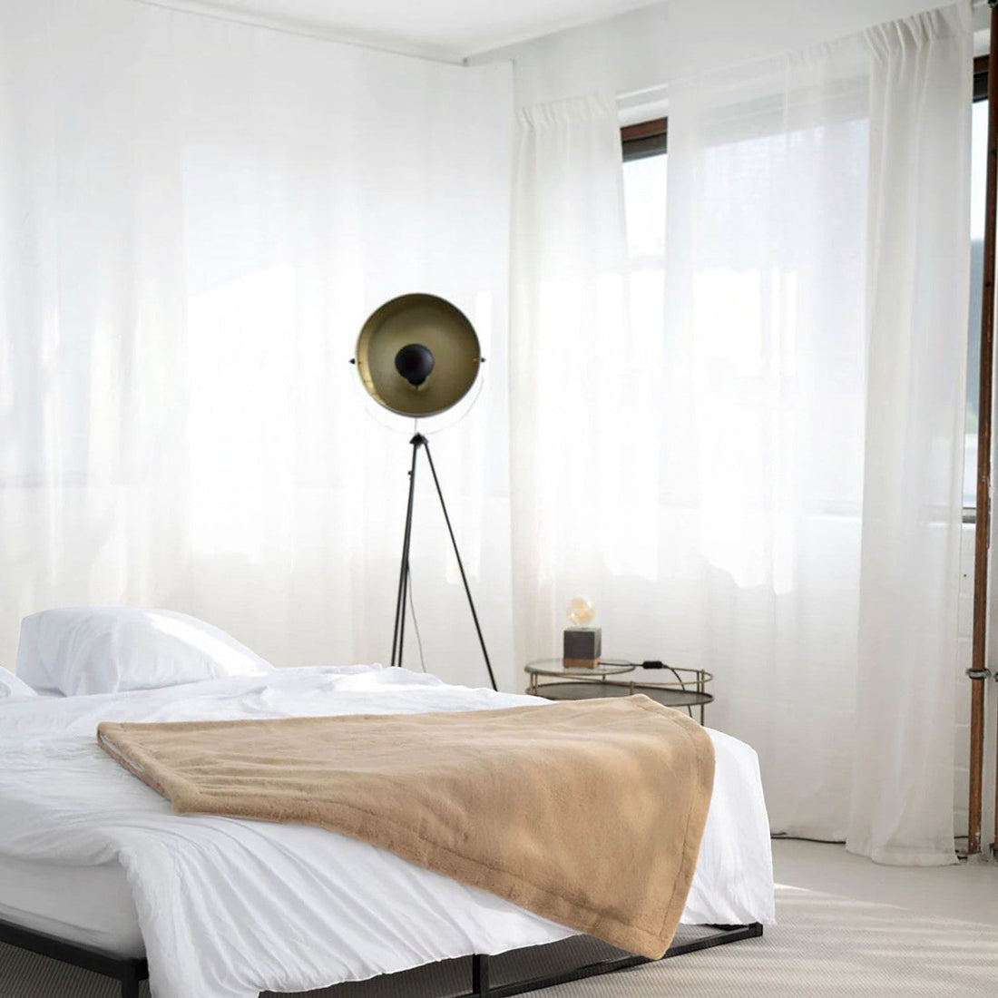 havaneser.shop Wohndecke aus Webpelz in Beige und Braun, gefaltet auf einem grauen Polsterhocker