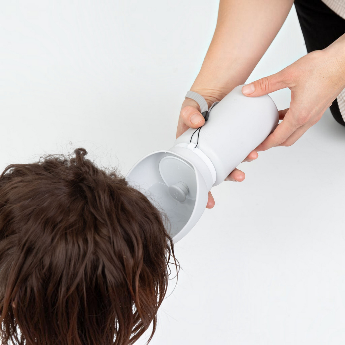 havaneser.shop On-the-Go Duo Trinkflasche in Grau, die einem Havaneser Wasser aus dem integrierten Napf spendet.