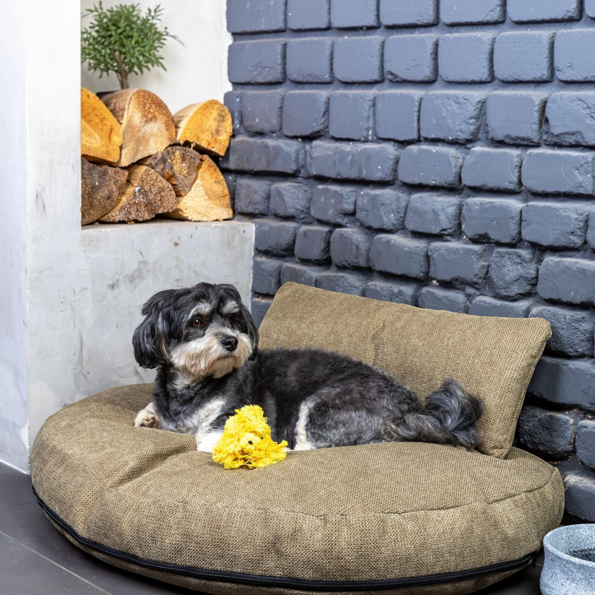 710b8b92-e370-4a73-8b2b-50e8ca6ef55e/ruby_loungekissen_olive_bg_brick_wall_angle.jpg